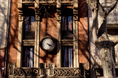 Low angle view of illuminated clock hanging on ceiling in old building