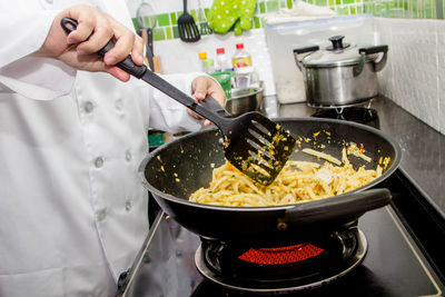 Midsection of man having food in kitchen