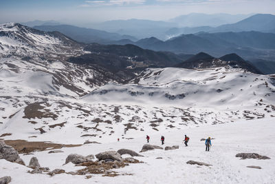 High angle view of people walking on snow covered land