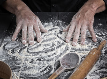 Cropped hands preparing food on table