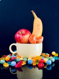 Close-up of fruits on table against black background
