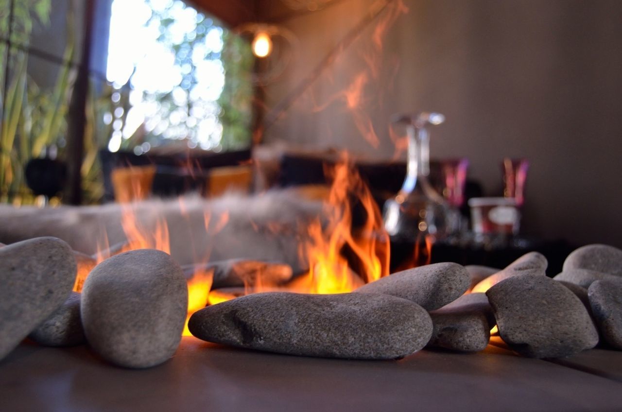 focus on foreground, selective focus, flame, indoors, burning, art and craft, close-up, sculpture, human representation, spirituality, statue, religion, art, creativity, illuminated, fire - natural phenomenon, candle, figurine, heat - temperature