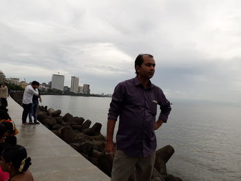 Man standing by sea against sky