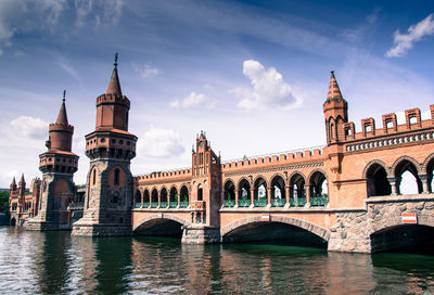 Low angle view of oberbaum bridge over river against sky