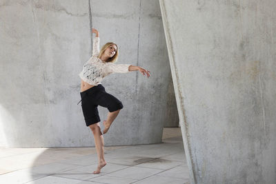 Full length of woman standing against wall