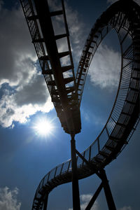 Low angle view of silhouette ferris wheel against sky