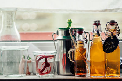 Close-up of drinks in bottles on table against window