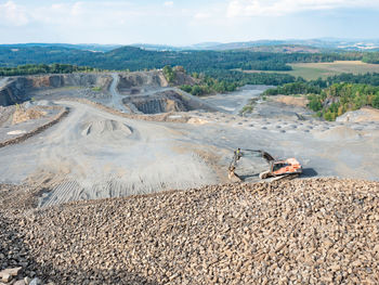 Worn out loader between piles of crushed basalt stones. mining excavator, stone crusher and loader