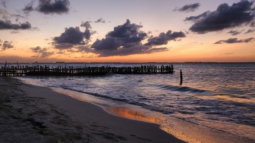 Scenic view of beach against sky during sunset