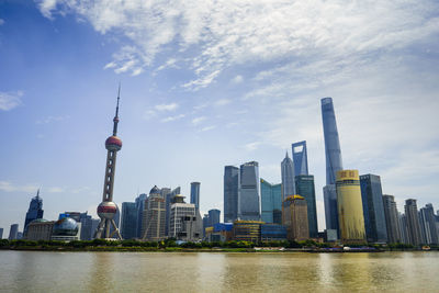 View of buildings in city against cloudy sky