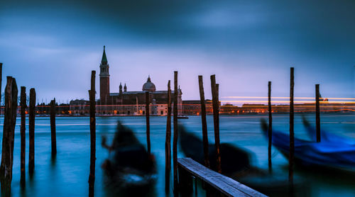 Wooden posts in grand canal at dusk