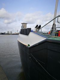 Ship moored at harbor against sky