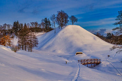 Hill covered with snow with wooden stairs.