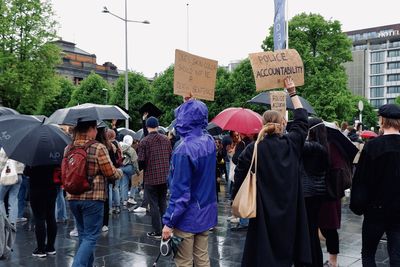 People protesting for black lives matter on wet street in city