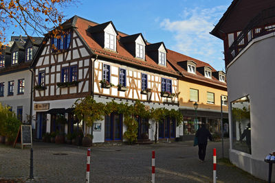 Residential buildings by street against sky