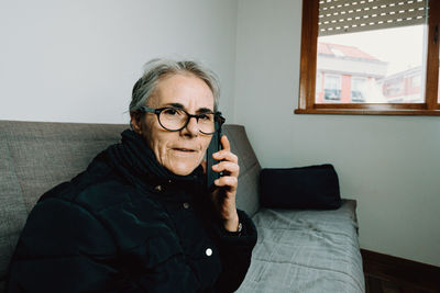 Portrait of mature woman talking phone at home