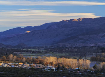 Scenic view of lake by mountains against sky