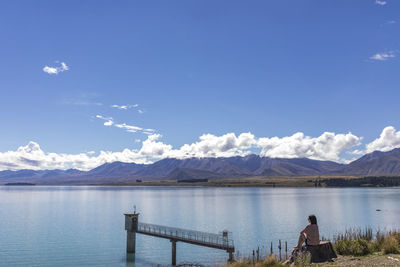 Rear view of people on lake against sky