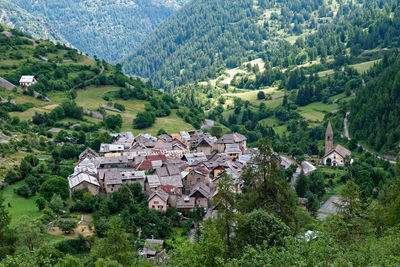 High angle view of village amidst trees and houses