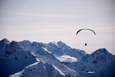 Low angle view of person paragliding against sky