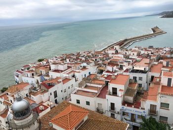 High angle view of townscape by sea against sky