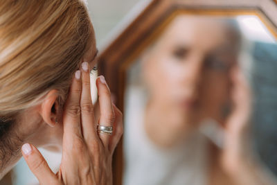 Concept of body dysmorphic disorder concept, woman looking at mirror obsessively.