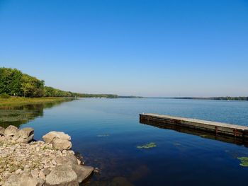 Scenic view of lake against clear blue sky