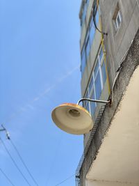 Low angle view of telephone pole against building