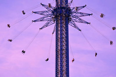 Low angle view of chain swing ride against sky