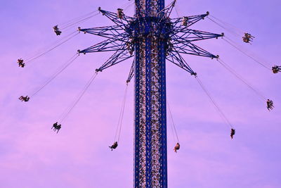 Low angle view of chain swing ride against sky during sunset