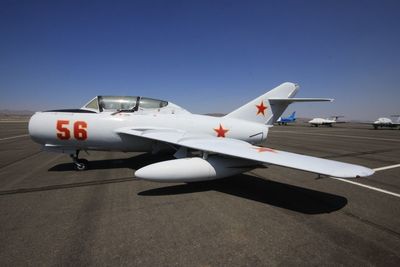 Fighter airplane on runway against clear sky