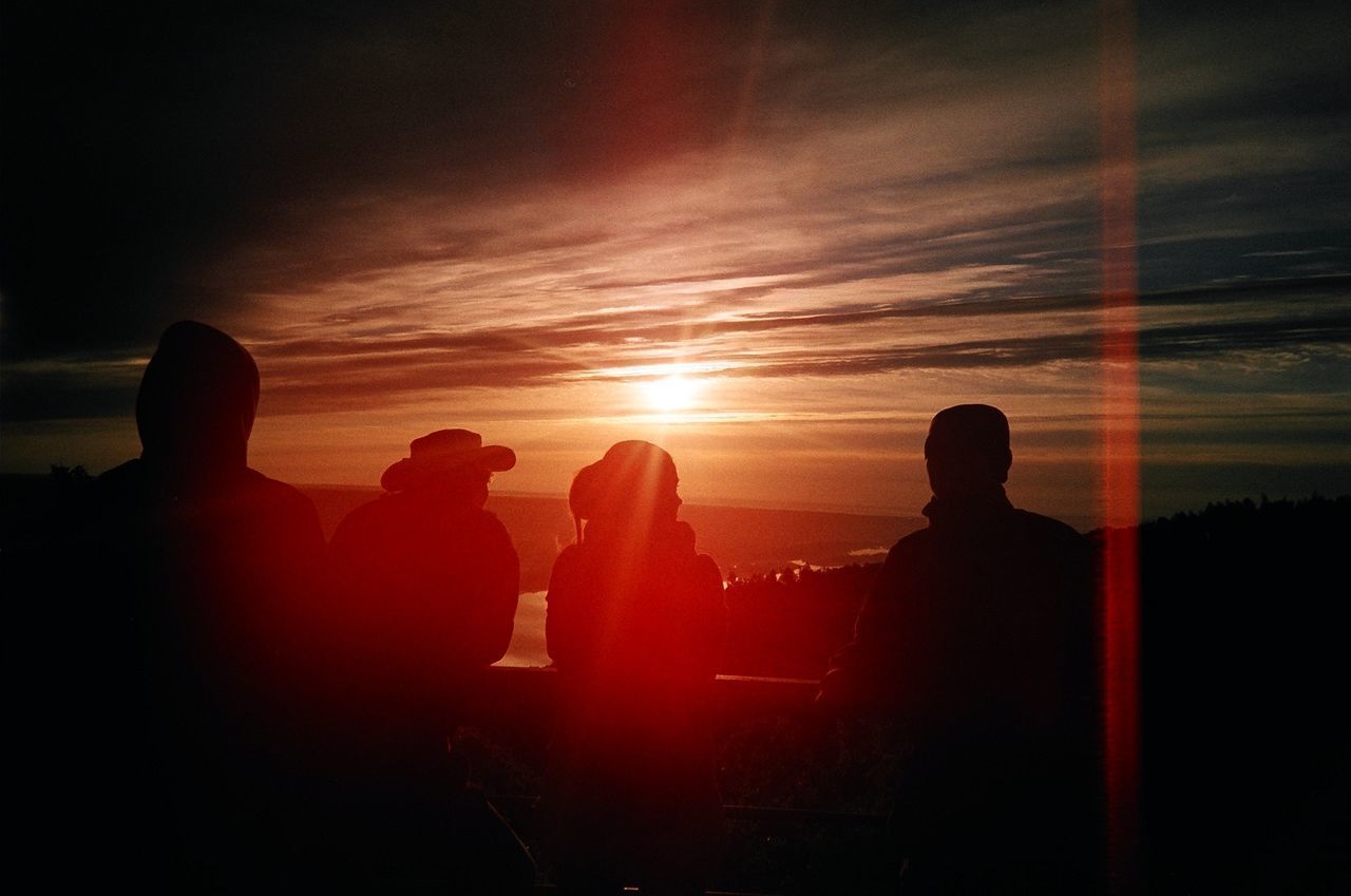 SILHOUETTE PEOPLE STANDING AGAINST ORANGE SKY