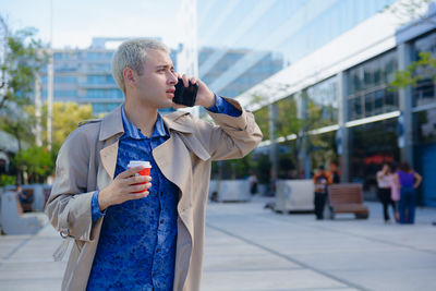 Side view of young man photographing in city