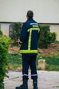 Rear view of man standing against wall