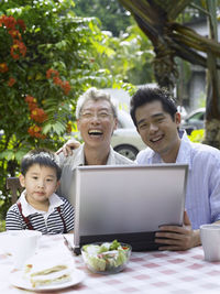 Portrait of happy family using laptop