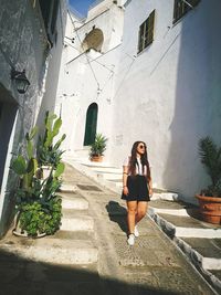 Full length of woman sitting against building