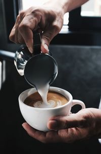 Close-up of hand holding coffee cup