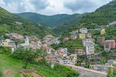 Buildings in town by mountains against sky