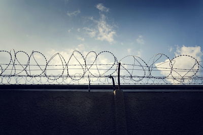 Barbed wire fence against sky