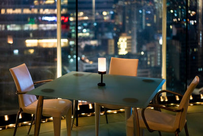Empty chairs and tables in restaurant at night