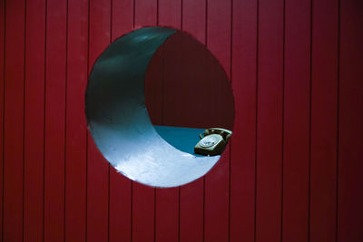 Rotary phone seen through circle on wall in office