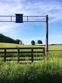 Information sign on field against sky