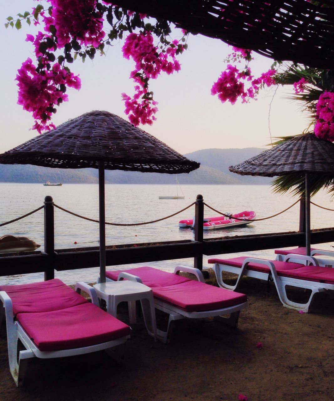 CHAIRS AND TABLES ON BEACH AGAINST SKY