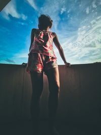 Rear view of woman standing against sky