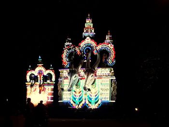 Low angle view of illuminated building against sky at night