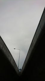 Low angle view of bridge and building against sky