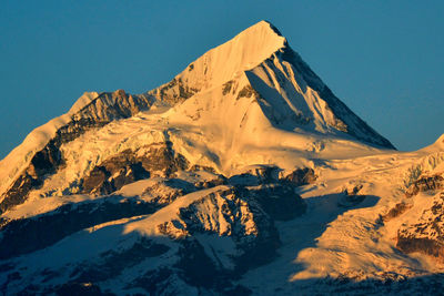 Scenic view of snowcapped mountains against clear sky