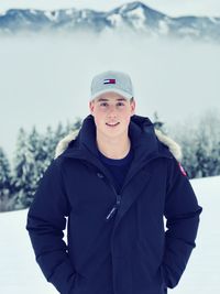 Portrait of young man standing in snow