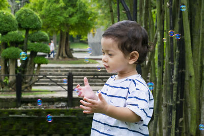 Cute boy looking up while standing outdoors