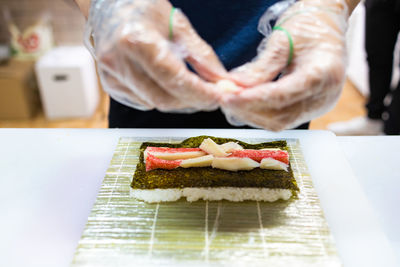 Cropped hand of person holding food on table